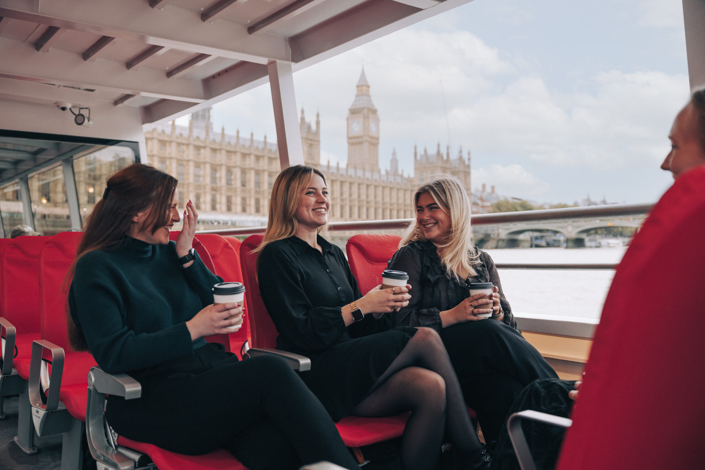 Three friends enjoying the Tower of London River Tour, keeping warm with a mulled wine
