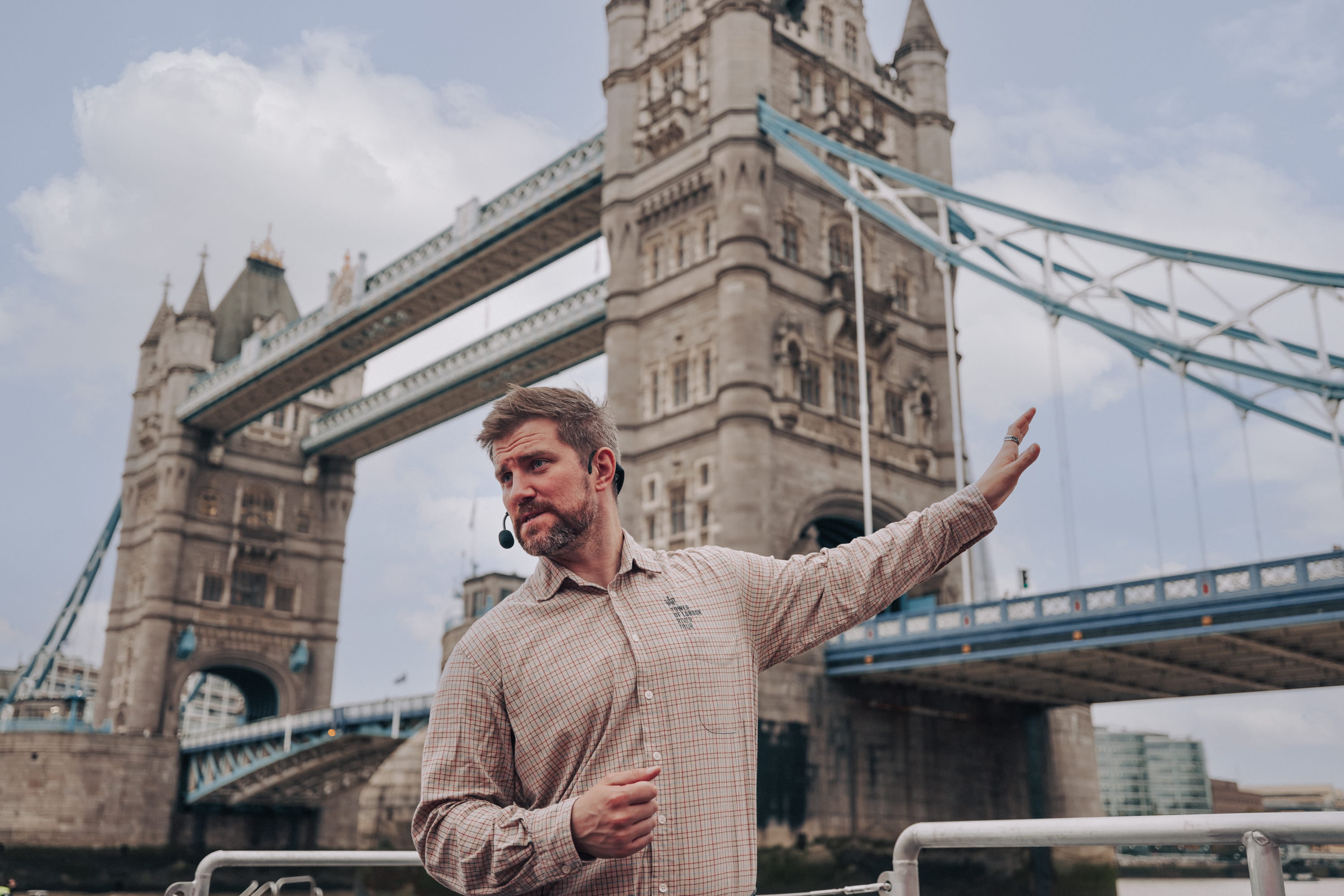 Guide-delivering-a-tour-aboard-the-Tower-of-London-River-Tour-with-Tower-Bridge-in-view