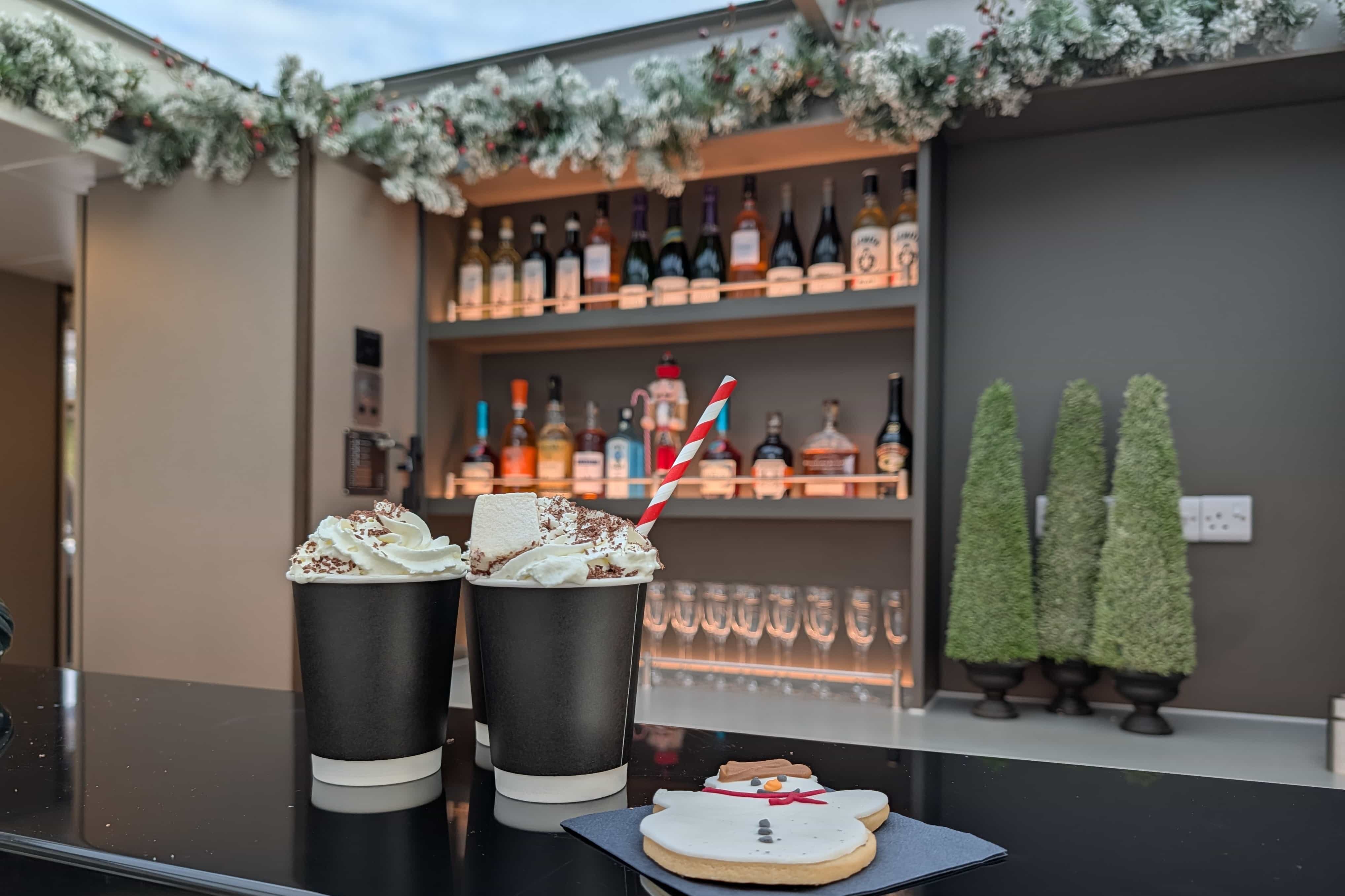 Two luxurious hot chocolates with a snowman biscuit on the Tower of London River Tour onboard bar