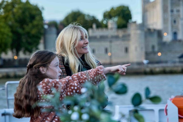 Family sightseeing boat cruise passing the historic Tower of London.