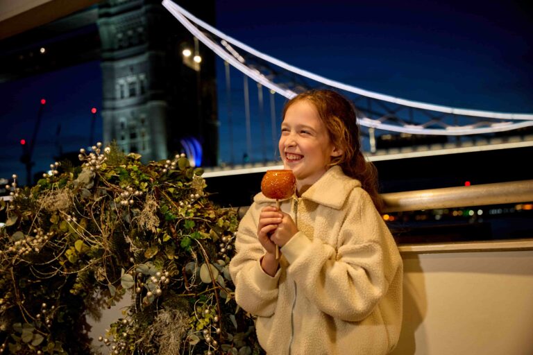 Festive evening family river cruise with treats and illuminated views of Tower Bridge