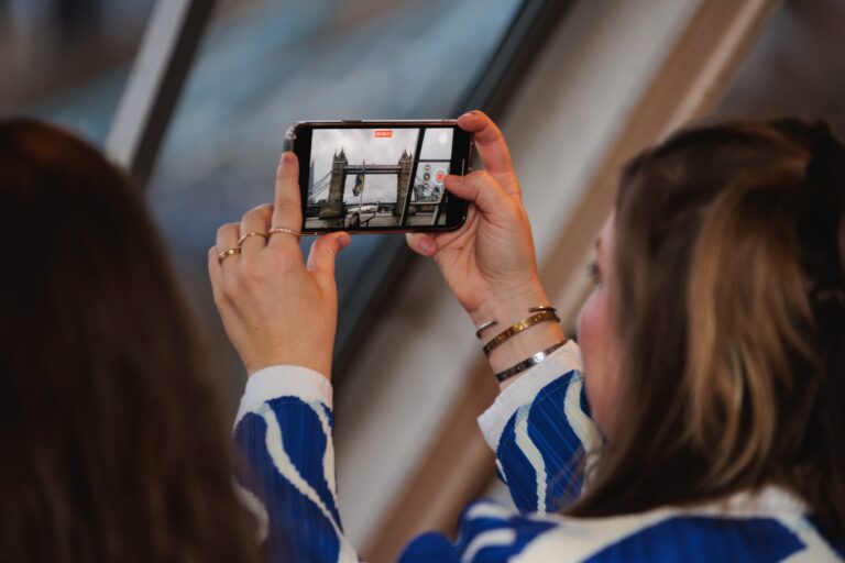 Visitor photographing Tower Bridge with a mobile phone aboard a boat ©Captis Imagery